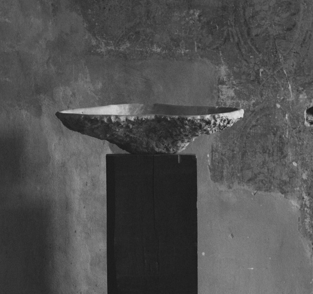 K2130 sculptural stone vessel by Isac Elam Kaid resting on a dark monolithic plinth.